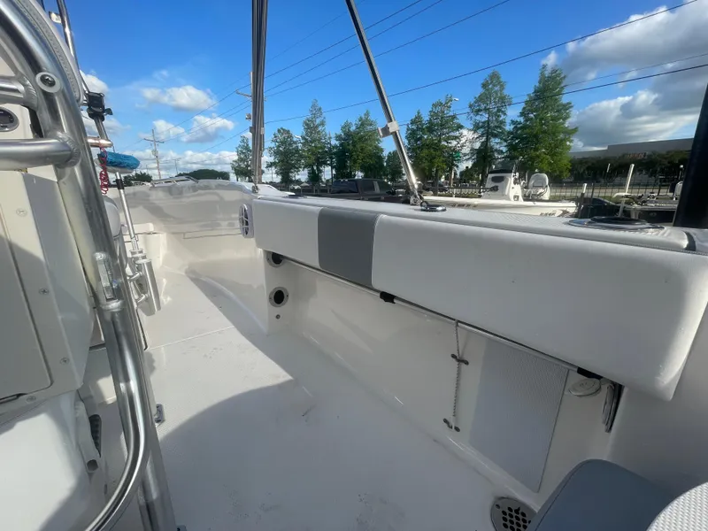 Slide: The Image of 2021 Robalo R180 Center Console boat interior with white seating and clear blue sky. - 20