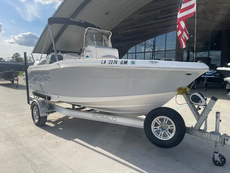 Slide: The Image of 2021 Robalo R180 Center Console boat on trailer with American flag. - 7