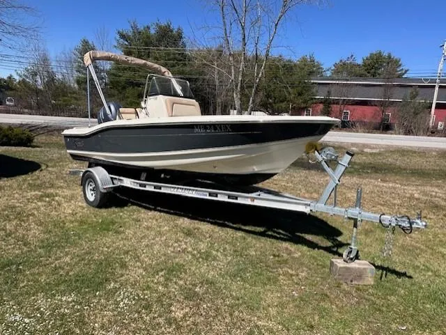 The Image of 2022 Scout 175 Sportfish boat on trailer, parked on grass, sunny day. - 0