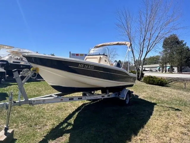 Slide: The Image of 2022 Scout 175 Sportfish boat on trailer, parked on grass under clear blue sky. - 1