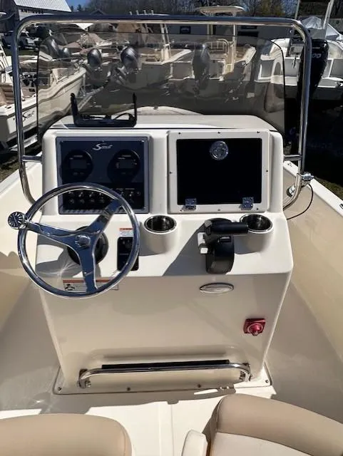 Slide: The Image of 2022 Scout 175 Sportfish boat dashboard with steering wheel and navigation controls. - 4