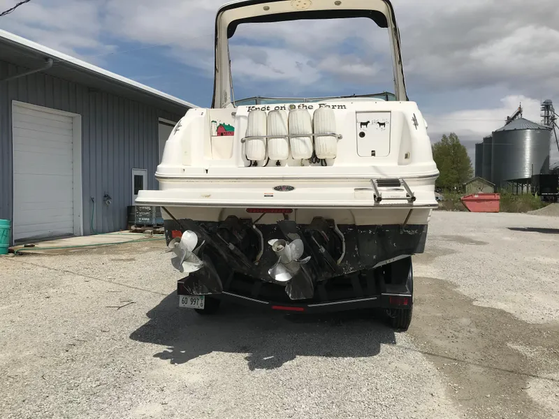 Slide: The Image of 2002 Chaparral Signature 300 boat, rear view, parked near a warehouse. - 17