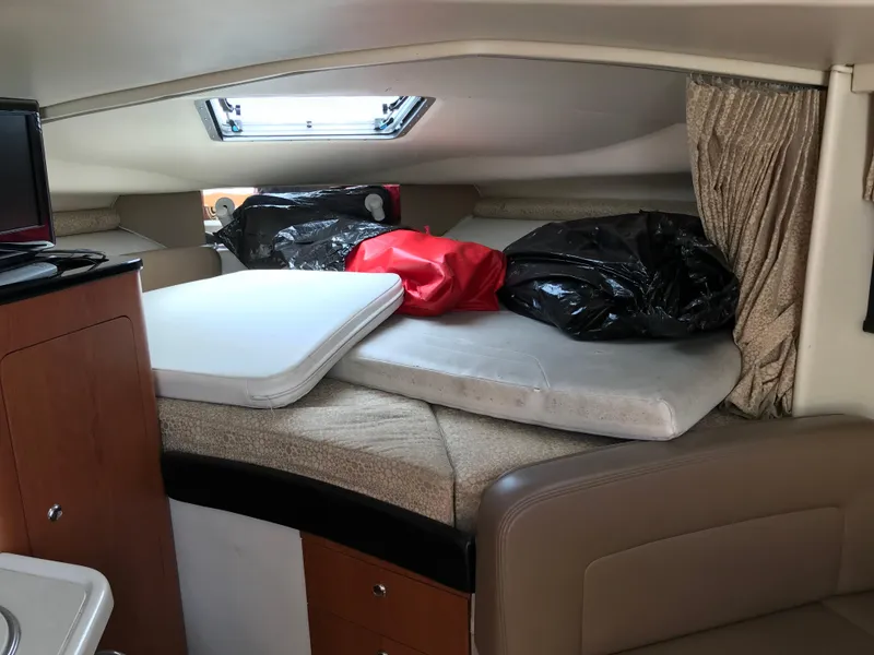 Slide: The Image of Interior cabin of a 2002 Chaparral Signature 300 boat with bedding and storage. - 22