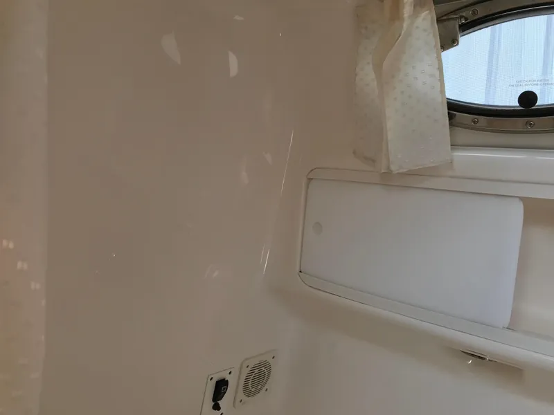 Slide: The Image of Interior cabin of 2002 Chaparral Signature 300 boat with porthole and curtain. - 31