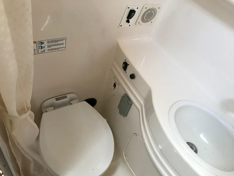 Slide: The Image of 2002 Chaparral Signature 300 boat bathroom with toilet and sink. - 32