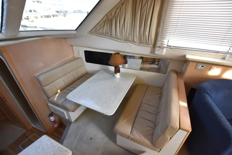 Slide: The Image of 1999 Carver 356 Aft Cabin interior dining area with cushioned seating and table. - 10