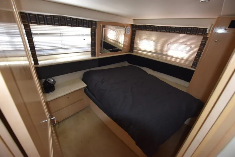 Slide: The Image of 1999 Carver 356 Aft Cabin bedroom with bed, windows, and storage cabinets. - 14