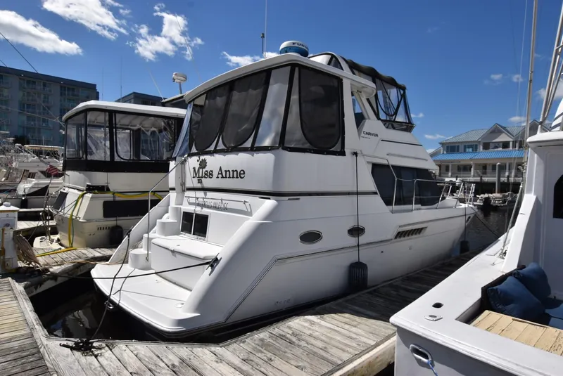 Slide: The Image of 1999 Carver 356 Aft Cabin yacht docked at marina under clear blue sky. - 2