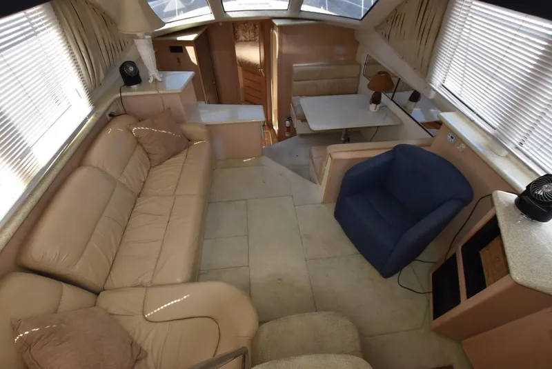 Slide: The Image of Interior of 1999 Carver 356 Aft Cabin yacht with beige leather seating and blue armchair. - 7