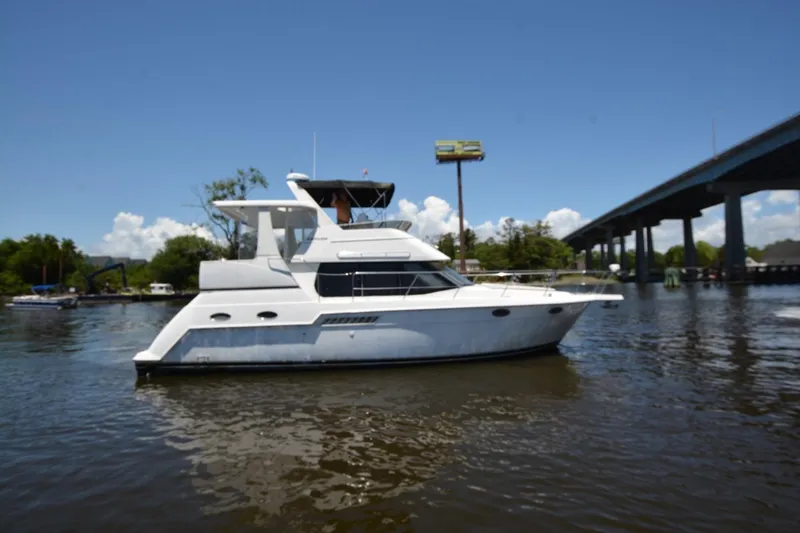 The Image of 1999 Carver 356 Aft Cabin Motor Yacht on a sunny day near a bridge. - 0
