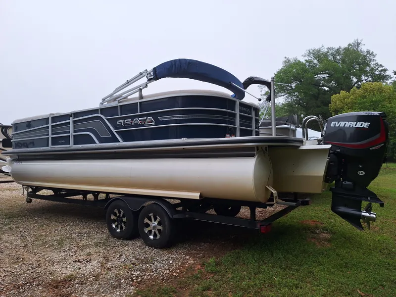 The Image of 2017 Ranger REATA pontoon boat on a trailer with Evinrude outboard motor. - 1