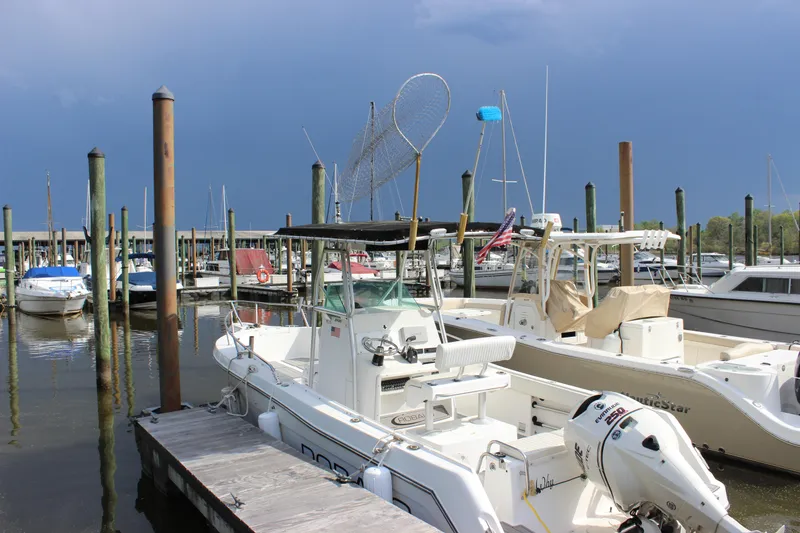 Slide: The Image of 1999 Robalo 2420 Center Console boat docked at a marina. - 1