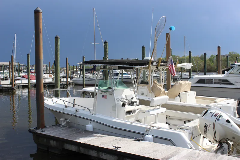 Slide: The Image of 1999 Robalo 2420 Center Console boat docked at a marina. - 2