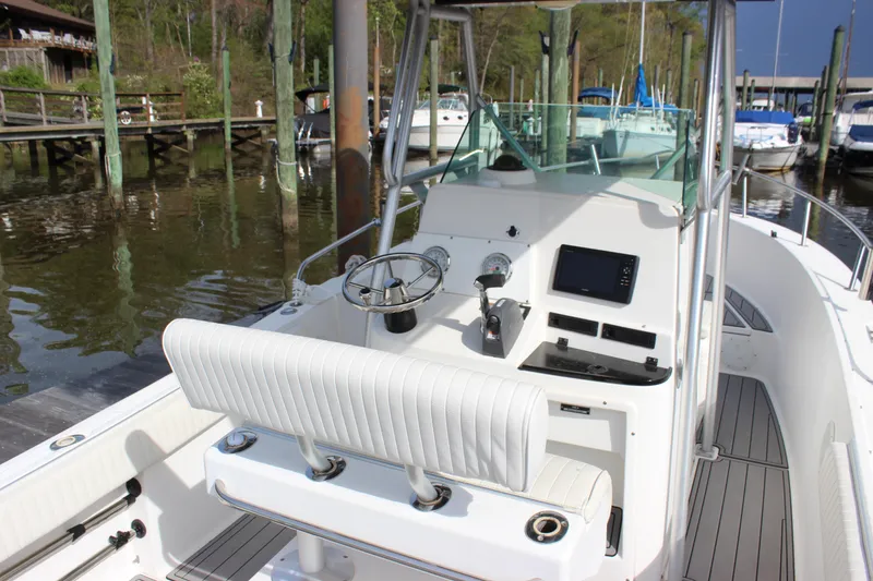 Slide: The Image of 1999 Robalo 2420 Center Console boat docked, featuring a clean helm and seating area. - 4