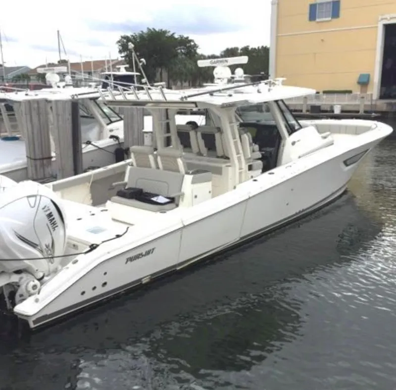 Slide: The Image of 2022 Pursuit S 428 Sport boat docked in marina, side view. - 1