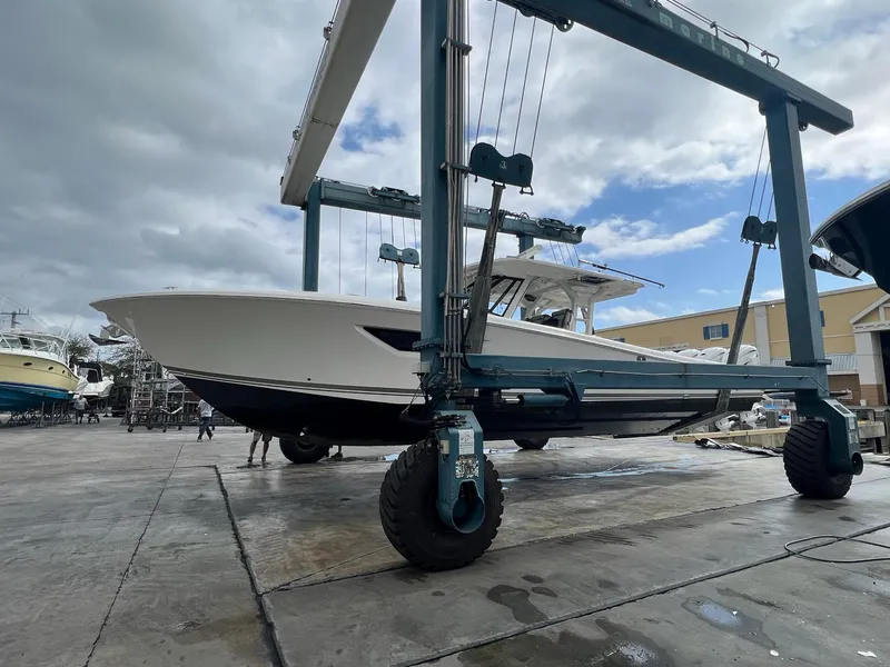 Slide: The Image of 2022 Pursuit S 428 Sport boat on a lift at a marina. - 2
