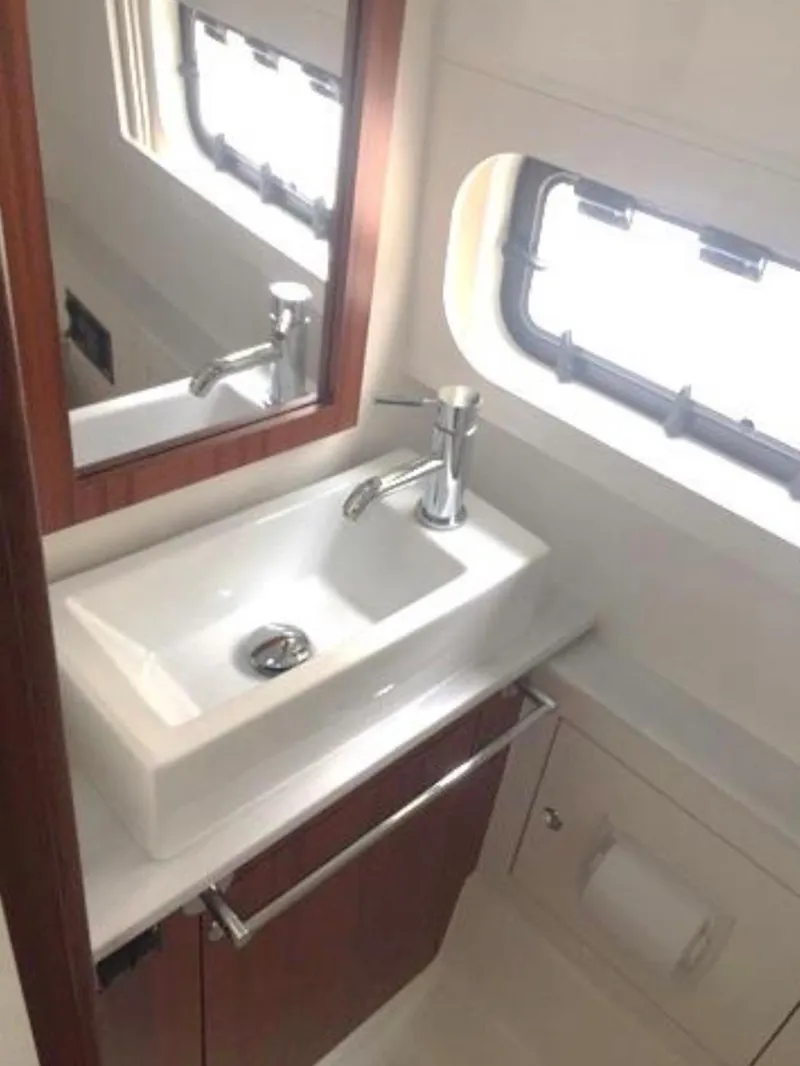 Slide: The Image of 2022 Pursuit S 428 Sport boat bathroom with modern sink and window. - 24