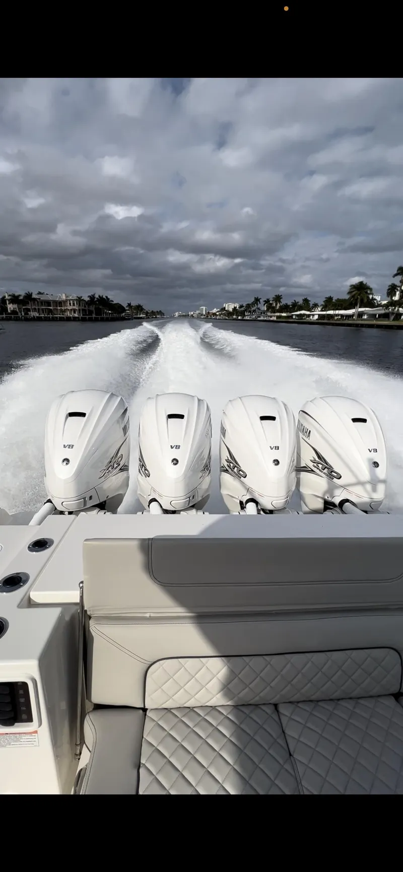 Slide: The Image of 2022 Pursuit S 428 Sport boat with quad outboard engines cruising on water. - 6
