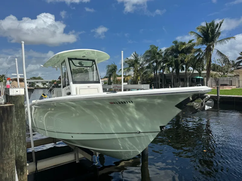 The Image of 2022 Sea Hunt 27 Gamefish boat docked near palm trees and waterfront homes. - 0