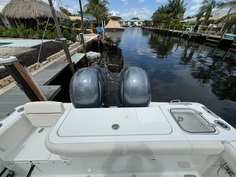 Slide: The Image of 2022 Sea Hunt 27 Gamefish boat docked in a canal with twin outboard engines. - 13