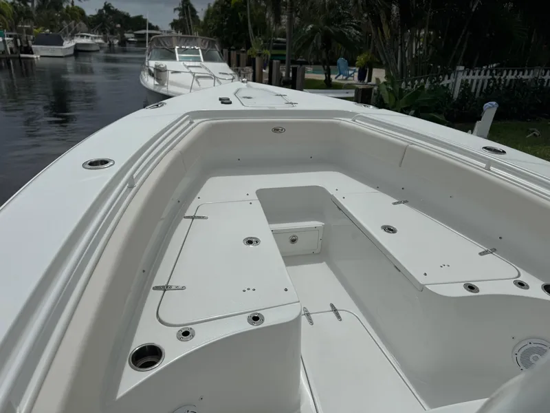Slide: The Image of 2022 Sea Hunt 27 Gamefish boat interior, docked in a serene canal. - 16