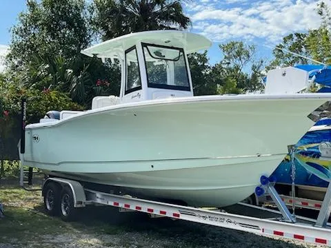 Slide: The Image of 2022 Sea Hunt 27 Gamefish boat on a trailer in a tropical setting. - 2