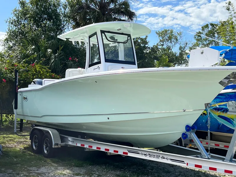 Slide: The Image of 2022 Sea Hunt 27 Gamefish boat on a trailer, parked outdoors. - 21