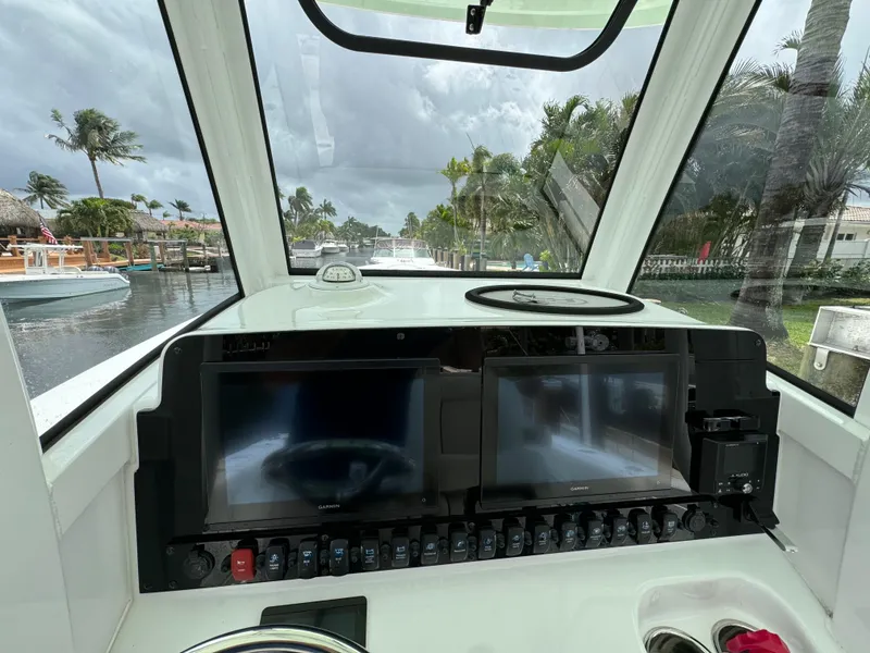 Slide: The Image of 2022 Sea Hunt 27 Gamefish helm with dual displays and waterfront view. - 5