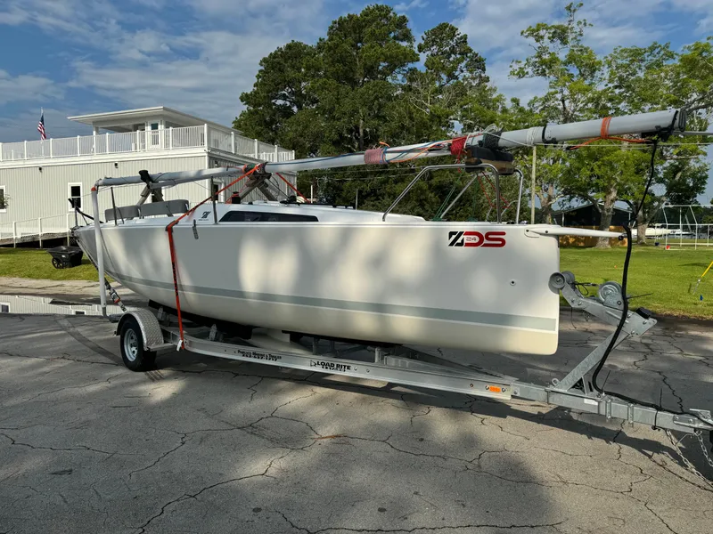 Slide: The Image of Sailboat on trailer, Zonda z24 2024 model, parked outdoors near trees and building. - 10