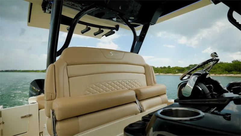 Slide: The Image of 2022 Scout 330 LXF boat interior with luxurious seating and steering console. - 18