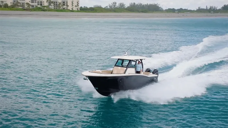 Slide: The Image of 2022 Scout 330 LXF boat cruising on open water near the shore. - 23