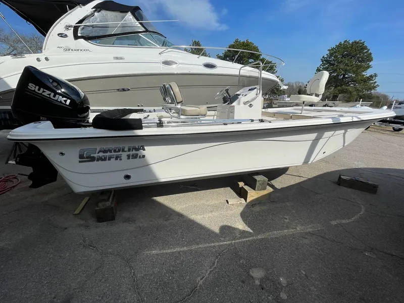 Slide: The Image of 2024 Carolina Skiff 19 LS boat with Suzuki outboard motor on a trailer. - 0