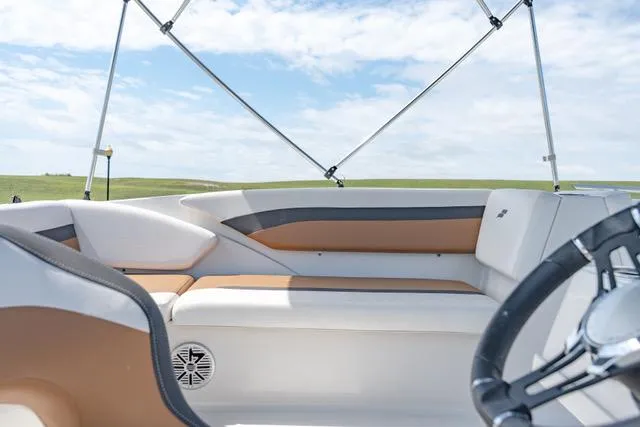 Slide: The Image of 2022 Starcraft SVX 171 OB boat interior with cushioned seating and steering wheel. - 3