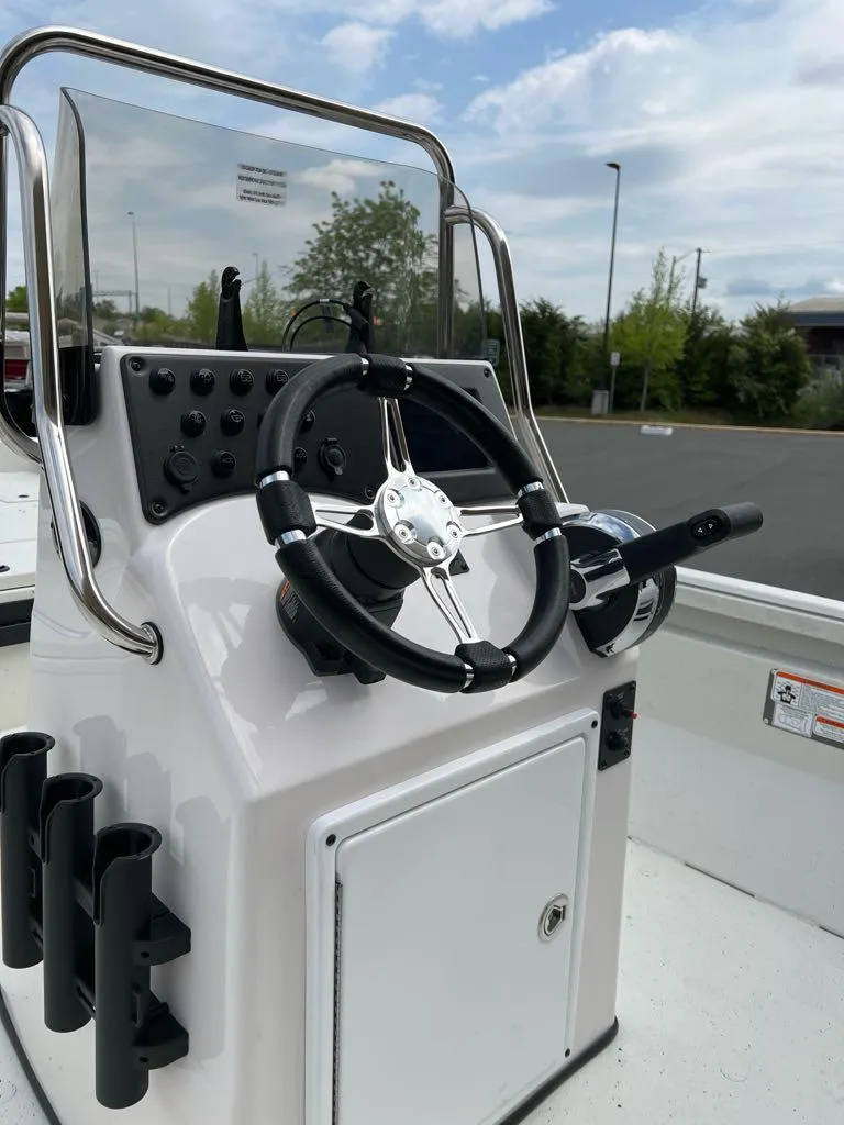 Slide: The Image of 2024 Ranger RB210 boat console with steering wheel and rod holders. - 1