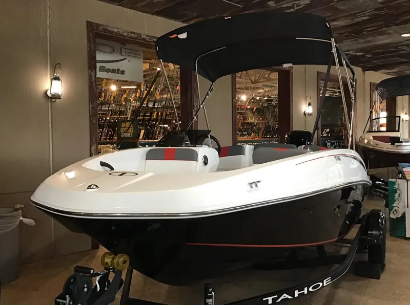 Slide: The Image of 2024 Tahoe T16 boat with canopy displayed indoors. - 0