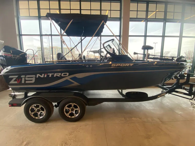 Slide: The Image of 2024 Nitro ZV19 Sport Pro boat displayed indoors on a trailer. - 0