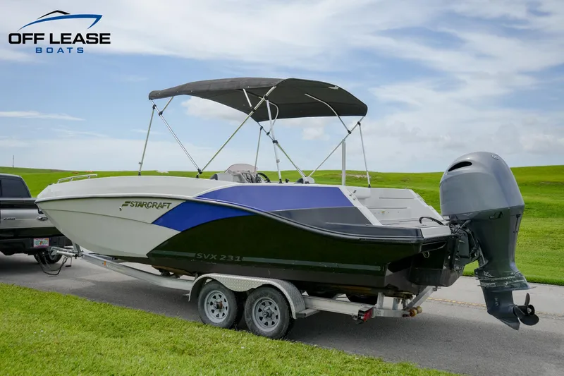 Slide: The Image of 2022 Starcraft SVX 231 OB boat on a trailer with a black canopy. - 9