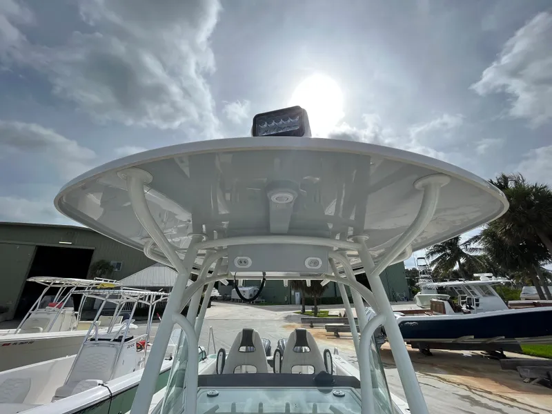 Slide: The Image of 2023 Sailfish 290 CC center console boat under a cloudy sky. - 14