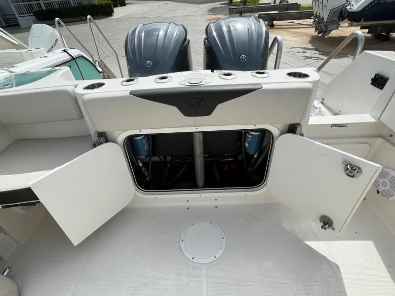 Slide: The Image of 2023 Sailfish 290 CC boat with open storage compartment and twin outboard engines. - 17