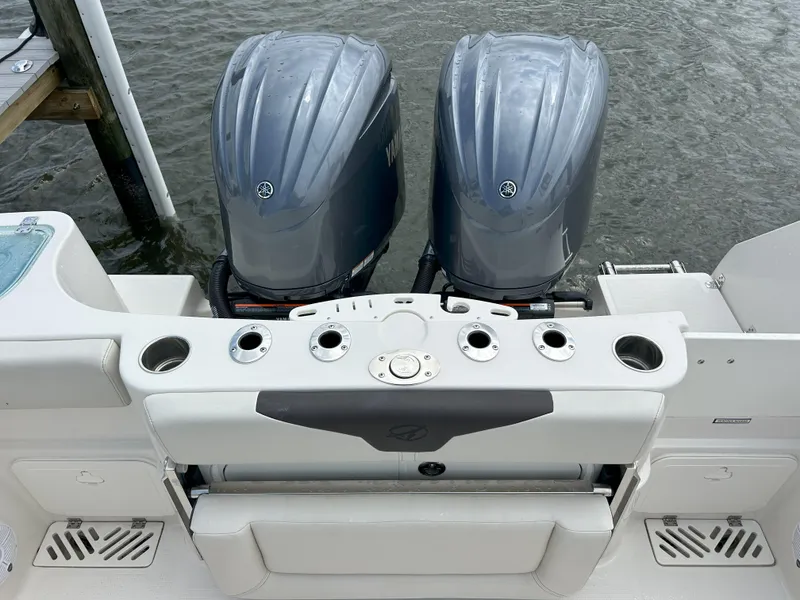 Slide: The Image of 2023 Sailfish 290 CC boat with twin outboard motors docked. - 2