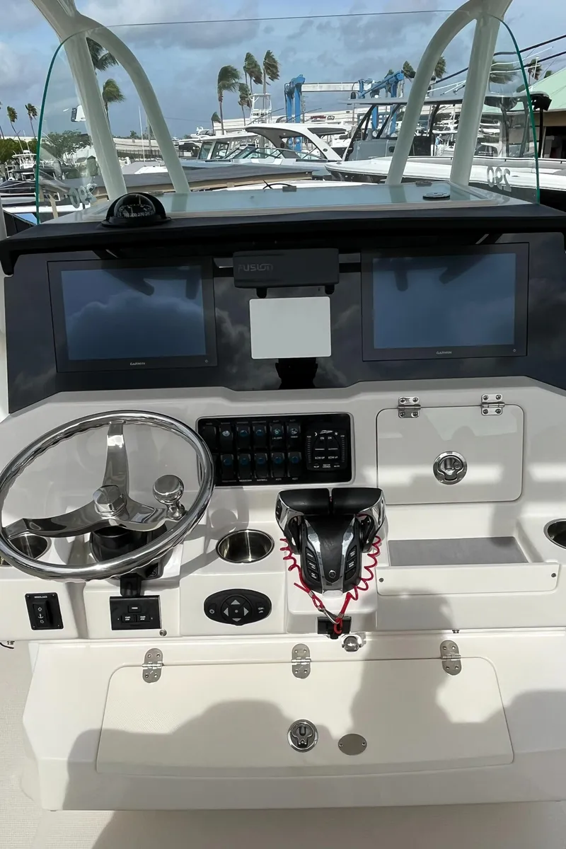 Slide: The Image of 2023 Sailfish 290 CC boat helm with dual screens and steering wheel. - 24