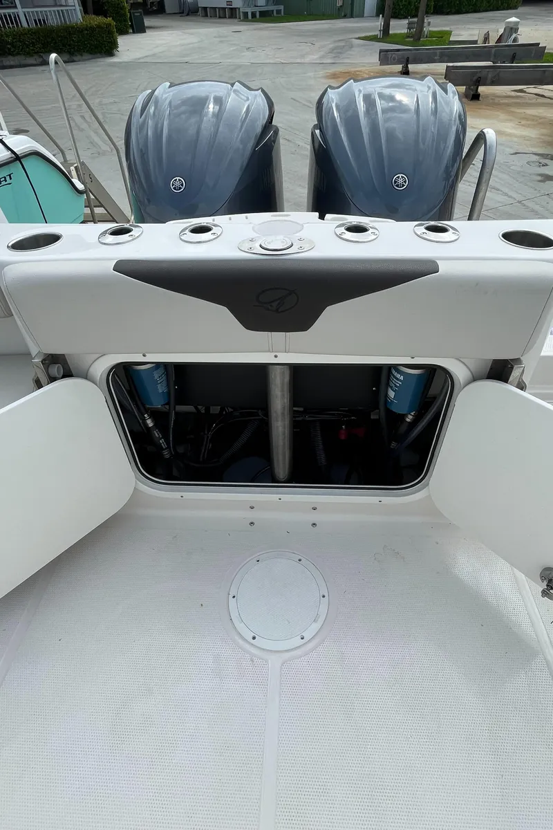 Slide: The Image of 2023 Sailfish 290 CC boat with open storage compartment and twin outboard engines. - 29