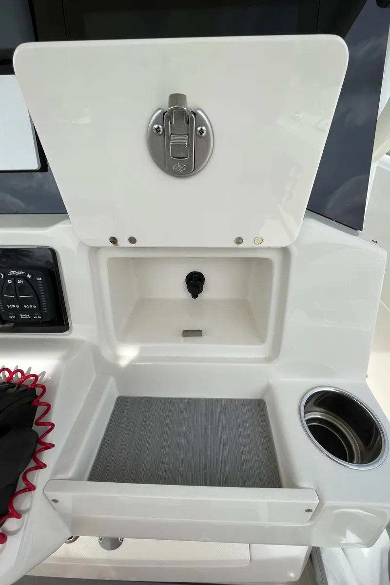Slide: The Image of 2023 Sailfish 290 CC console storage compartment with cup holder and control panel. - 31