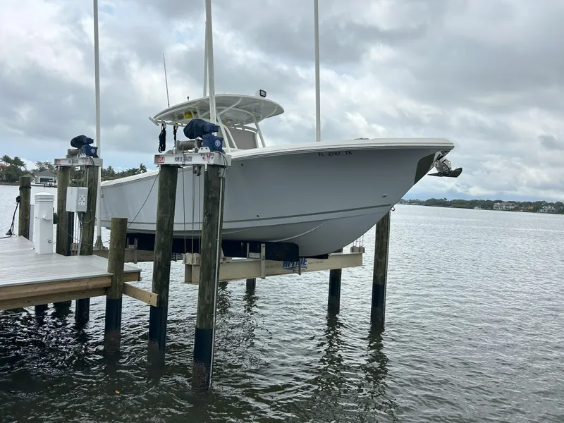 Slide: The Image of 2023 Sailfish 290 CC boat docked on a lift over water. - 33