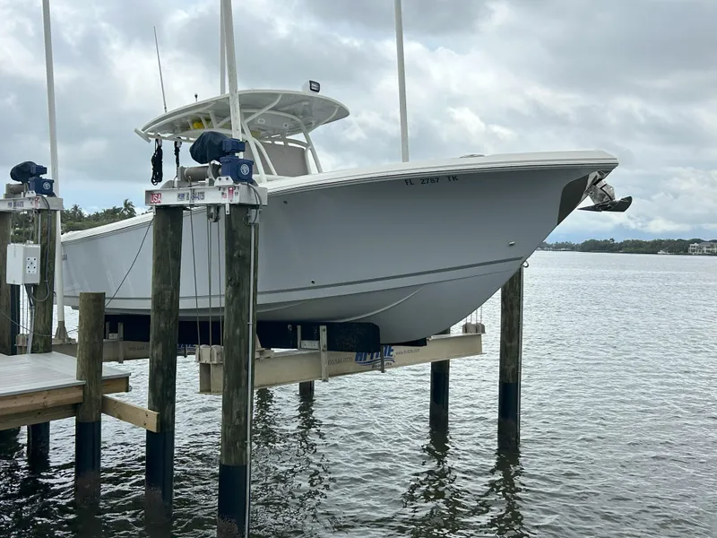 Slide: The Image of 2023 Sailfish 290 CC boat on a lift at a dock. - 34