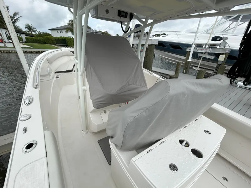 Slide: The Image of 2023 Sailfish 290 CC boat interior with covered seats docked at marina. - 40