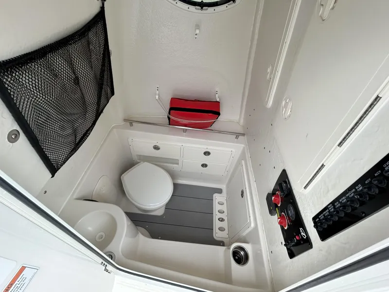 Slide: The Image of 2023 Sailfish 290 CC boat interior with toilet and sink. - 48
