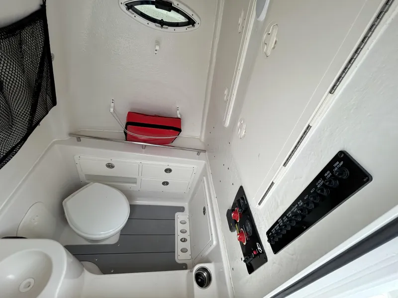 Slide: The Image of 2023 Sailfish 290 CC boat interior with toilet and control panel. - 49