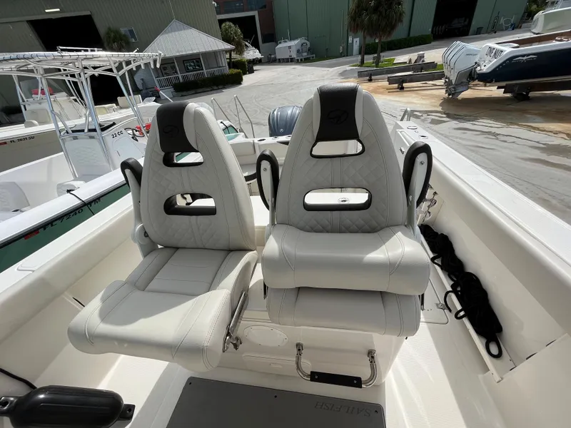 Slide: The Image of 2023 Sailfish 290 CC boat with dual white cushioned seats in the cockpit area. - 5