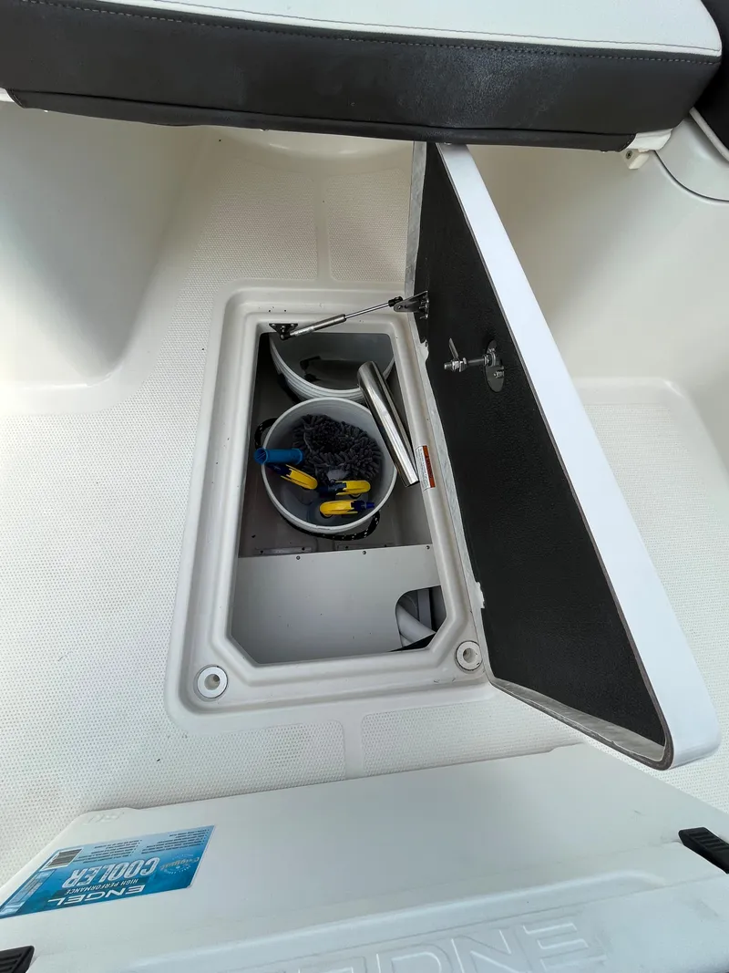 Slide: The Image of Storage compartment on a 2023 Sailfish 290 CC boat with cleaning supplies. - 8